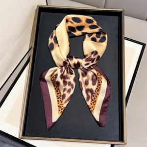 Elegant leopard print silk scarf with burgundy borders tied in a stylish bow knot