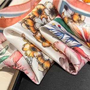 Close-up of elegant floral silk scarf showing vibrant petals and smooth texture