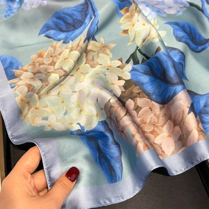 Detailed view of light blue satin silk square scarf with elegant hydrangea floral patterns