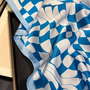 Detailed view of flowing blue and white checkered wave patterns on premium silk scarf