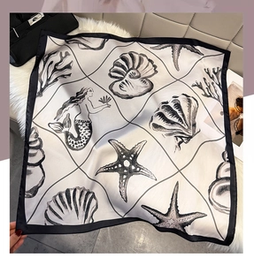 Detail of square silk scarf with nautical shell and mermaid print on faux fur background
