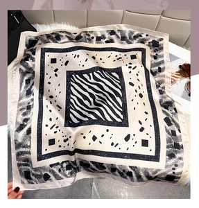 Close-up of geometric silk-like square scarf with zebra and polka dot patterns