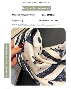 Detailed macro shot of beige silk-like polyester scarf with black geometric pattern