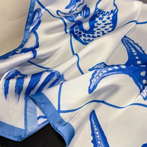 Detailed close-up of shell print silk scarf with smooth satin finish and rolled edges