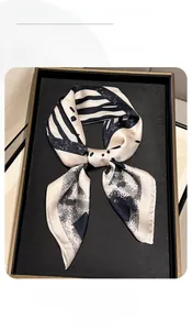 Detail showing high-quality silk-like scarf with black and white geometric pattern