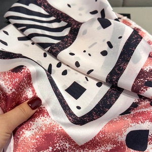 Detailed view of satin scarf showing zebra print and geometric dot patterns