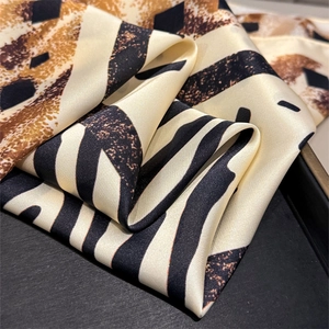 Detailed view of silk-like scarf featuring leopard print and black white stripes