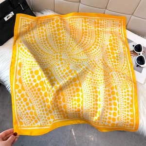 Foulard di seta a pois gialli e bianchi, bordi arrotolati, su fondo di pelliccia sintetica