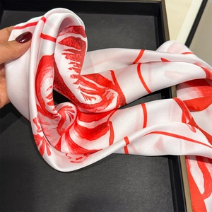 Detail of red and white floral print silk scarf featuring smooth lustrous texture