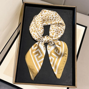 Detail of silk leopard scarf in yellow with greek key pattern in luxury gift box