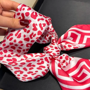 Detail of red and white silk scarf showing double-sided leopard and geometric patterns