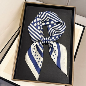Detail of blue and white striped silk scarf with polka dots on a black display tray