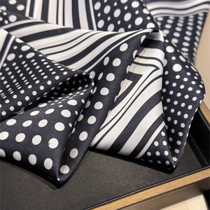 Vue détaillée du foulard en soie montrant le motif patchwork à pois et rayures classiques