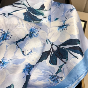 Elegant light blue silk scarf with white camellia floral print and silky texture