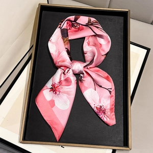 Elegant pink camellia silk scarf with floral print for women, tied in a soft knot