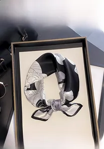 Detail of 100% mulberry silk camellia scarf elegantly tied inside a premium display box