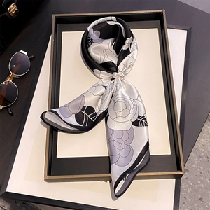 Elegant silk scarf with rose print and pearl buckle on monochrome display plate
