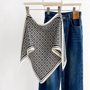 Foulard in seta con motivo geometrico bianco e nero appeso sopra jeans casual