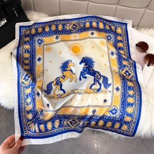 Detail of horse and sun pattern on navy blue and yellow luxury silk square scarf