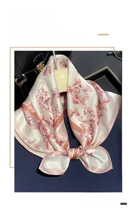 Détail d'un carré de soie avec imprimé papillon rose et texture satinée lisse