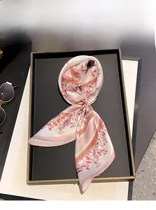 Détail d'un foulard en soie à imprimé papillon avec une boucle décorative en perles