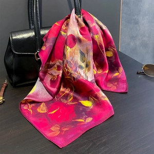 Foulard en soie à imprimé rose élégamment drapé sur un sac à main avec accessoires de mode