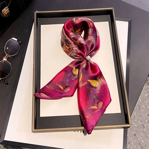 Foulard en soie à imprimé floral rose avec boucle perle sur plateau mode