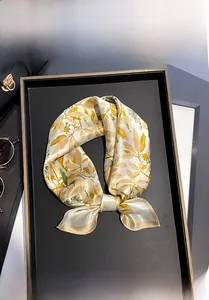 Detail shot of 100% Mulberry silk scarf with green and yellow leaf prints on beige