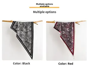 Detailed view of paisley silk scarves in black and red hanging on natural wood