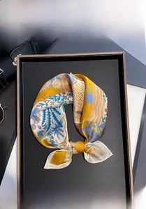 Gros plan d'un foulard carré en 100% soie de mûrier aux motifs floraux et géométriques