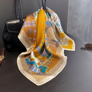 Élégant foulard en soie à motifs floraux drapé sur un sac à main de luxe chic