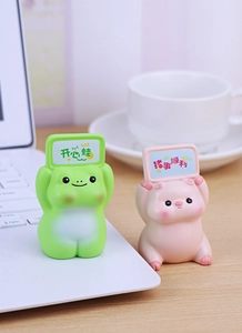 Detail of cute resin pig and frog animal figurines with desktop good luck signs