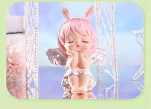 Détail d'une figurine d'ange pour gâteau avec cheveux roses et oreilles de lapin mignon