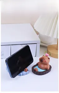 Detailed view of Capybara phone stand in wooden tub with rotating pink heart feature