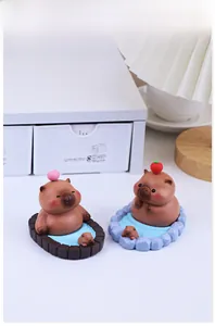 Macro detail of capybara figurines in bath tubs as desk accessories for office decor