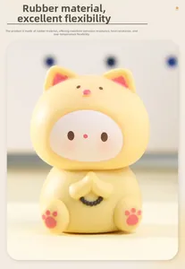 Detailed view of a cute yellow vinyl cat figurine with praying hands and black bead necklace