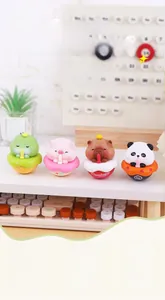 Close-up of animal tumblers including a brown capybara and pink pig on a desk