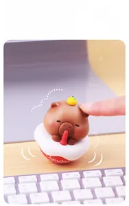 Close-up of a brown Capybara tumbler toy with orange decoration on a desktop