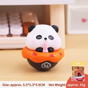 Cute panda tumbler desk ornament in orange container on a wooden office tabletop