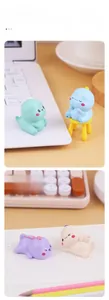 Miniature resin dinosaur figurines in pastel colors displayed on a desk with a keyboard