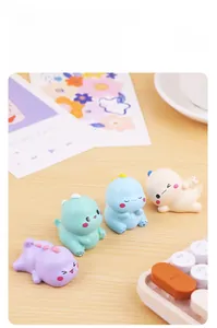 Set of four cute mini dinosaur figurines in pastel colors on a wooden office desk