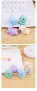 Detailed view of four colorful mini dinosaur figurines on a wooden office desk setup