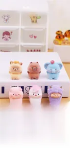 Detailed view of mini flocked animal figurines in pastel colors on a white book