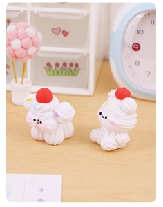 Detail of two cute resin dog figurines with cream-textured waves and cherry decoration