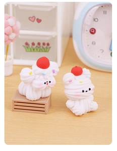 Detailed view of miniature resin cream bears with strawberry accents for cake decor