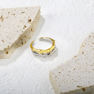 Detailed close-up of double-layered wavy two-tone open ring on natural stone