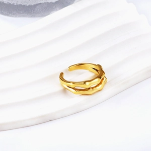 Dual-layer golden wave open ring with minimalist liquid metal design on white pedestal