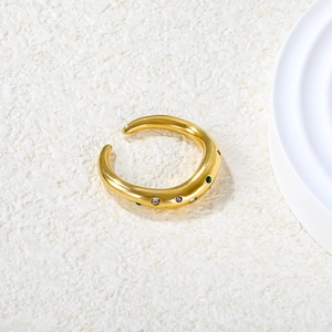 Minimalist 18k gold wave ring with multi-colored stones on a marble textured background