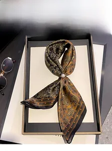 Détail d'un foulard en soie de mûrier à motif cachemire avec épingle en perle de luxe