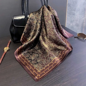 Détail du foulard en soie à motif paisley noué sur un sac en cuir avec style